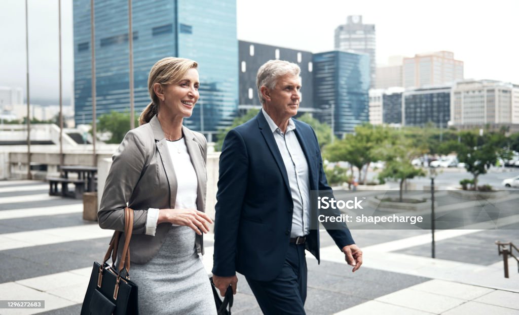 man and woman in professional attire smiling at the camera Photo by Rebrand Cities: https://www.pexels.com/photo/man-and-woman-smiling-inside-building-1367269/